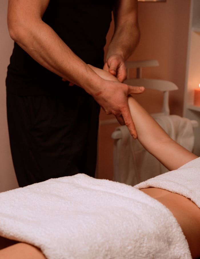 A comforting arm massage given by a masseur in a serene spa setting, promoting relaxation.